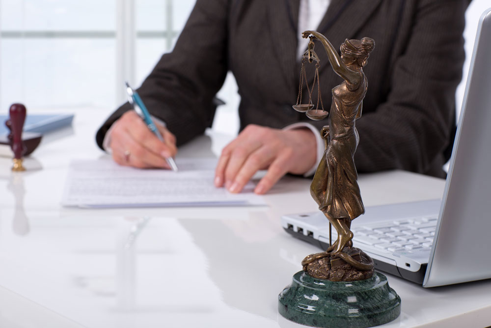 documents Lawyer sitting at desk signing a document